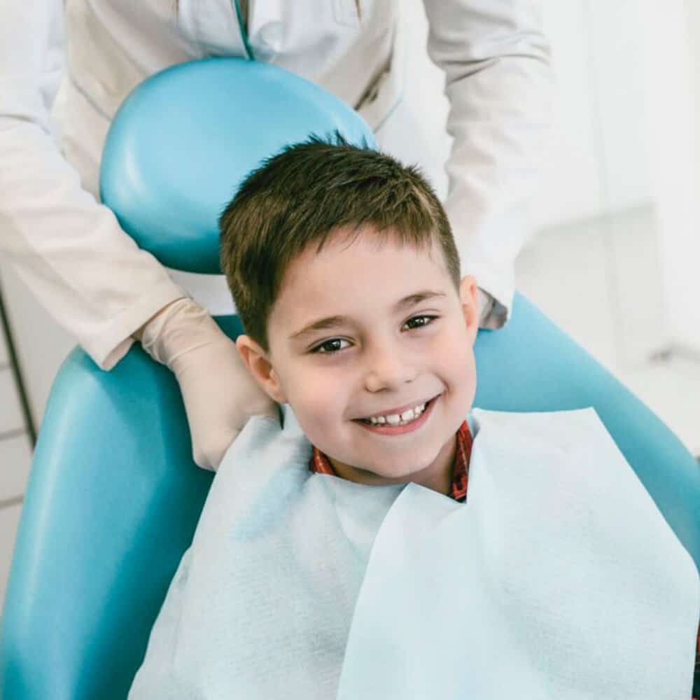 Young boy smiling in dental chair during checkup at North Salt Lake Dental office.